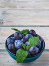 Fresh blueberries in blue bowl and leaves of mint on white wooden table Royalty Free Stock Photo