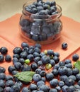 Fresh blueberries for eating. Juicy blue berries are in the glass jug. Heap of them are scattered on the rustic canvas Royalty Free Stock Photo