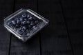 Fresh blueberries inside plastic container on black background Royalty Free Stock Photo