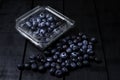 Fresh blueberries inside plastic container on black background Royalty Free Stock Photo