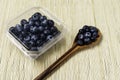 Fresh blueberries inside plastic container over bamboo background Royalty Free Stock Photo