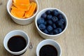 Fresh blueberries, orange slices and two cups of black coffee