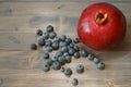 Blueberries and pomegranate on old wood background