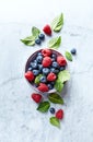 Fresh blueberries and raspberries with mint leaves in a ceramic bowl. Royalty Free Stock Photo