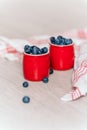 fresh blueberries in red pots on a wooden background, on a drop of water berries.