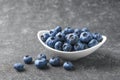 Fresh blueberries in a small round bowl on dark concrete background Royalty Free Stock Photo