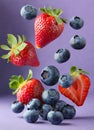 Fresh blueberries and strawberries falling on violet background