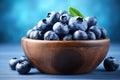 Fresh blueberries in wooden bowl on blue background. Blueberry antioxidant, Fresh blueberries in wooden bowl on blue wooden table