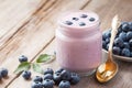 Fresh blueberries yogurt in jar and saucer with bilberries