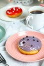 Fresh Blueberry Donut with cup of coffee served in plate Isolated on napkin side view of baked breakfast food