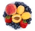 Fresh blueberry, strawberry, peach and apricot on a white plate Royalty Free Stock Photo