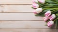 Fresh bouquet of pastel pink tulips on a wooden background with space for text