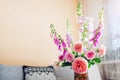 Fresh bouquet of roses and foxgloves flowers put in vase in living room. Interior and home decor. Pink orange blooms Royalty Free Stock Photo