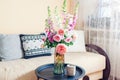 Fresh bouquet of roses and foxgloves flowers put in vase in living room. Interior and home decor. Pink orange blooms Royalty Free Stock Photo