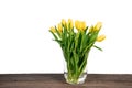 Bouquet of yellow tulips in vase on wooden table. Royalty Free Stock Photo