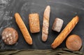 Fresh bread on a black background, top view. Homemade fresh pastries of various loaves of wheat and rye bread close-up. Royalty Free Stock Photo