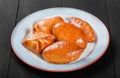 Fresh bread buns pies patties in plate on black wooden background. Bakery products. Hot and healthy breakfast, Royalty Free Stock Photo