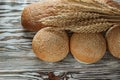 Fresh bread long loaf wheat ears on wooden surface