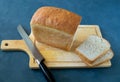 Fresh bread made of white wheat flour and a knife on a cutting board Royalty Free Stock Photo