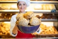 Fresh bread presented by an attractive young sales woman in bakery