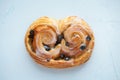 Fresh bread roll with raisins and icing on a blue background. Top view Royalty Free Stock Photo