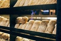 Fresh bread on shelves stand of a shop or bakery. Freshly baked bread loaves at window of store front. Organic pastry. Space for Royalty Free Stock Photo