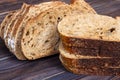 Fresh bread slices on cutting board against white wooden background Royalty Free Stock Photo