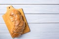 Fresh bread slices on cutting board against white wooden background. Top view Royalty Free Stock Photo