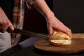 Whole grain bread put on kitchen wood plate with a chef holding knife for cut. The healthy eating and traditional bakery Royalty Free Stock Photo