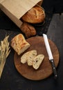 Whole grain bread put on kitchen wood plate with a knife for cut. Fresh bread on table close-up. Fresh bread on the Royalty Free Stock Photo