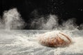 Fresh bread on table with powder in a freeze motion of a cloud of powder midair. Culinary, cooking, bakery concept Royalty Free Stock Photo