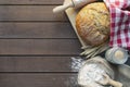 fresh bread with wheat ears and sack of flour, yeast, rolling pin on dark table, top view Royalty Free Stock Photo