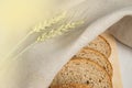 Fresh bread on a wooden chopping Board, wrapped in linen cloth, next to wheat ears, copy space, top view. Brown whole grain sliced Royalty Free Stock Photo