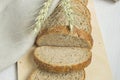 Fresh bread on a wooden chopping Board, wrapped in linen cloth, next to wheat ears, copy space, top view. Brown whole grain sliced Royalty Free Stock Photo