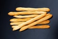 Fresh breadsticks lying on black