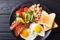 Fresh breakfast: fried eggs with bacon, beans, toast and vegetab Royalty Free Stock Photo