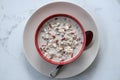 Fresh breakfast of granola, yogurt, nuts, goji berries, chia seeds and banana. Muesli with fruits and berries in red bowl Royalty Free Stock Photo