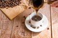 Fresh breved coffe in cezve traditional turkish coffee pot Woman`s hand pours coffee into white cup Royalty Free Stock Photo