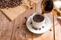 Fresh breved coffe in cezve traditional turkish coffee pot Woman`s hand pours coffee into white cup