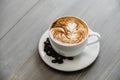 Fresh brewed coffee with fern pattern latte art in white cup