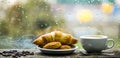 Fresh brewed coffee in white cup or mug on windowsill. Coffee drink with croissant dessert. Enjoying coffee on rainy day Royalty Free Stock Photo