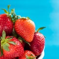 fresh bright strawberries in a bowl top view on a blue background Royalty Free Stock Photo