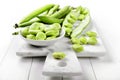 Fresh broad bean, fava beans on a marble cutting board on white wooden background, closeup. Royalty Free Stock Photo