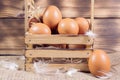 Fresh brown chicken eggs in a basket on a sacking on wooden background. Easter holidays background Royalty Free Stock Photo