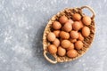 Fresh brown eggs in a basket on a gray background. View from above, flat lay.Copy space Royalty Free Stock Photo