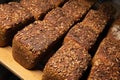 fresh brown loaves of rye bread in the form of bricks with sunflower seeds on a crust. Lie on a wooden rack Royalty Free Stock Photo