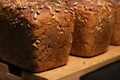 fresh brown loaves of rye bread in the form of bricks with sunflower seeds on a crust. Lie on a wooden rack Royalty Free Stock Photo