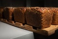 fresh brown loaves of rye bread in the form of bricks with sunflower seeds on a crust. Lie on a wooden rack Royalty Free Stock Photo