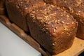 fresh brown loaves of rye bread in the form of bricks with sunflower seeds on a crust. Lie on a wooden rack Royalty Free Stock Photo