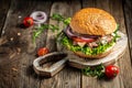 Fresh burger with blue cheese and arugula on wooden background. fast food and junk food concept Royalty Free Stock Photo